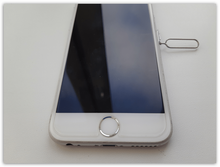 Открытие слота для сим-карты с помощью скрепки на iPhone