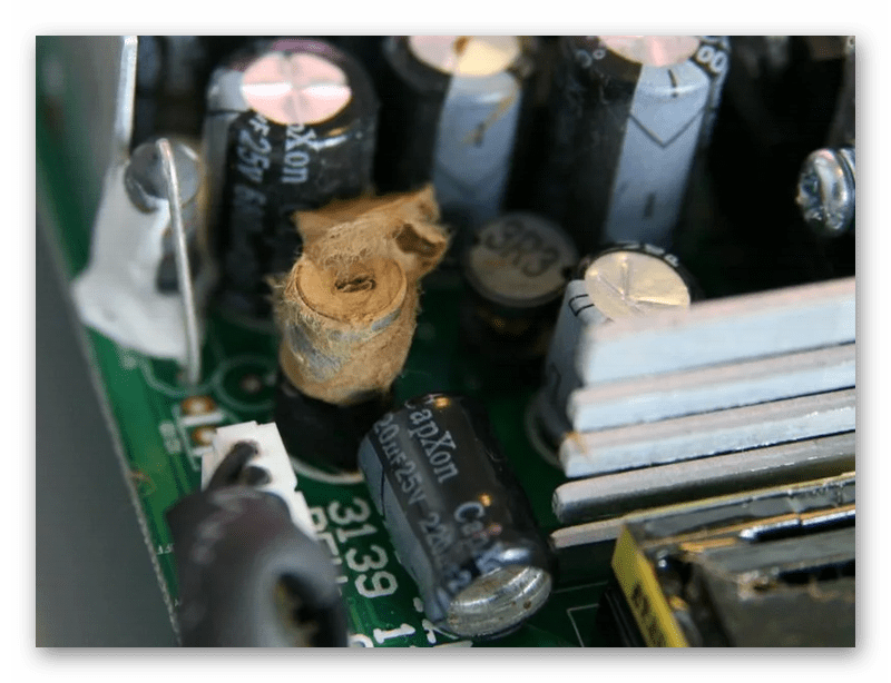 Взорванный электрический конденсатор на материнской плате компьютера
